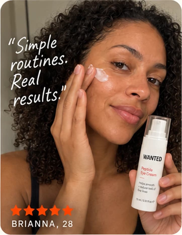 Brianna, 28, pressing cream into her cheek with the WANTED Peptide Eye Cream in hand.